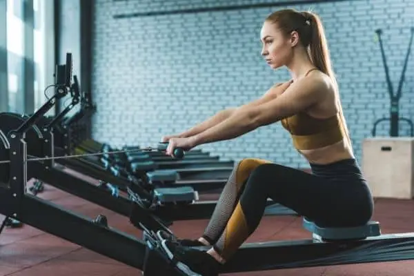 A woman using a stationary rowing machine