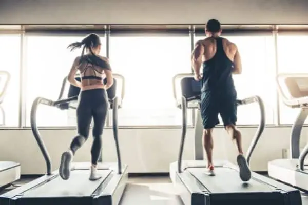 Two people running on a treadmill