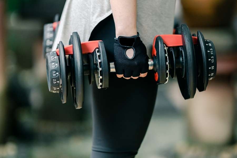Image of a woman holding adjustable dumbbells