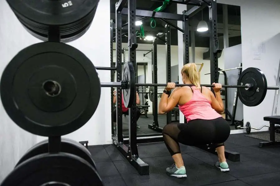 Woman squatting in a power rack