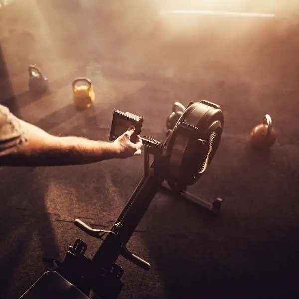 Image of a man setting a concept2 rowing machine.