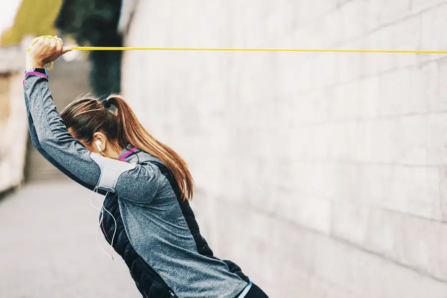 image of a woman doing an overhead extension with loop resistance band