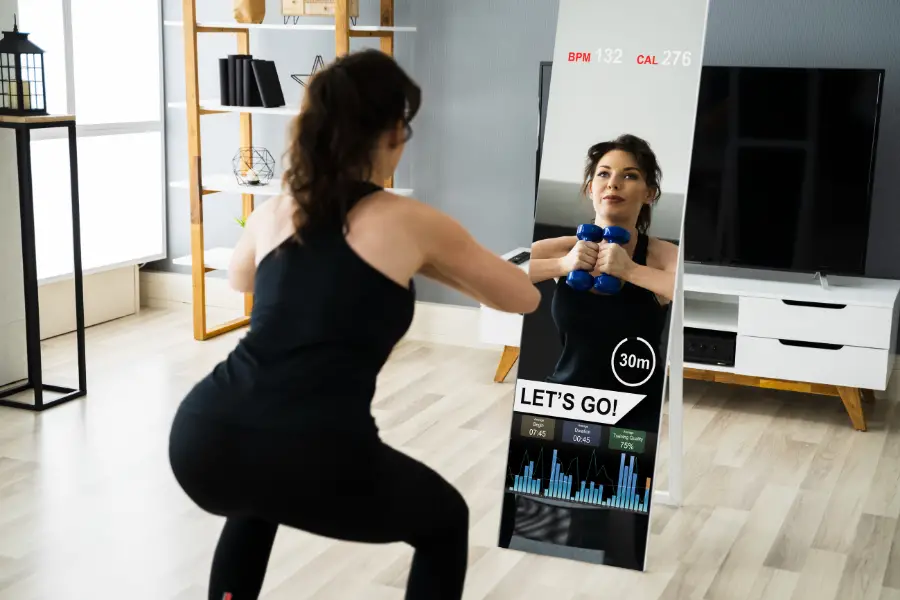 Woman working out at home in front of a smart fitness mirror.