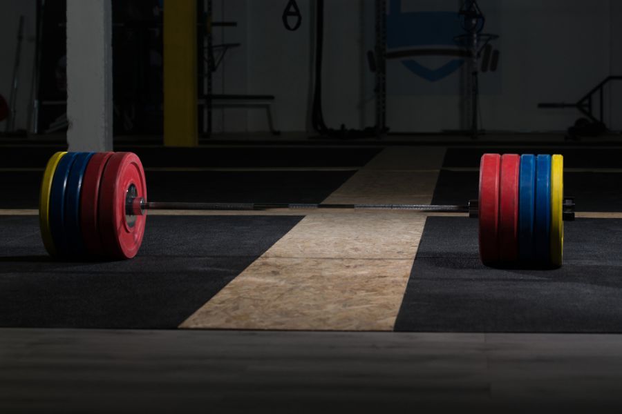 Image of a barbell with bumper plates on a weightlifting platform.